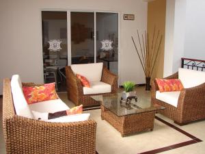 uma sala de estar com cadeiras de vime e uma mesa de centro em Hotel San Jeronimo em Popayán