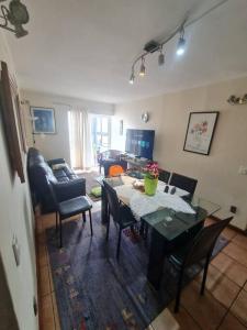 a living room with a table and chairs at Departamento Vina Centro (Portal Álamo) in Viña del Mar