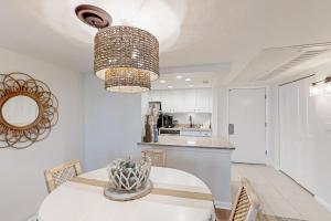 a dining room with a white table and a chandelier at 306 Sandcastles in Fernandina Beach