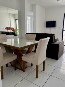 a dining room with a table and chairs and a couch at Apto próximo à Fac. Pio X in Aracaju