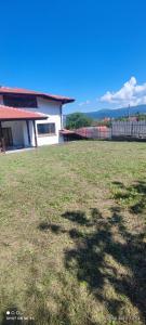 a yard with a house and a grass field at Guest house Asta in Saparewo