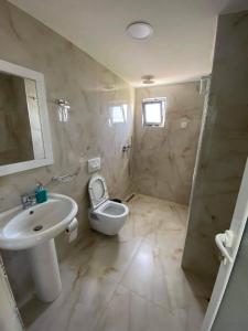a white bathroom with a sink and a toilet at Villa Festim Ksamil in Ksamil