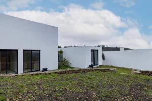 una casa blanca en una colina con un patio en Quinta Casal dos Coxos by LovelyStay, en Sobral de Monte Agraço
