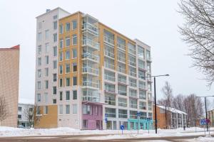 een groot appartementencomplex in een straat met sneeuw bij Cozy 1-bed super flat, 20 min to Helsinki/Airport in Vantaa