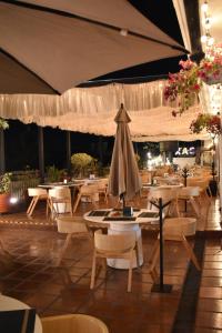 Un restaurante con mesas y sillas y una sombrilla. en Parador Monte Carmelo, en Oaxaca City