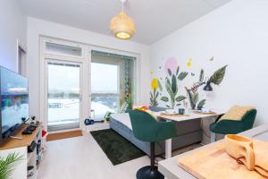 een woonkamer met een bureau, een bed en een computer bij Cozy 1-bed super flat, 20 min to Helsinki/Airport in Vantaa