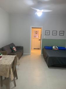 um quarto com uma cama, um sofá e uma mesa em Jk Beira Mar região central de Capão em Capão da Canoa