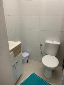 a white bathroom with a toilet and a sink at Jk Beira Mar região central de Capão in Capão da Canoa