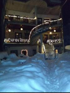 a snow covered building with a staircase in front of it at ΛΑΓΟΥΜΙ suite Α3 in Elati Trikalon