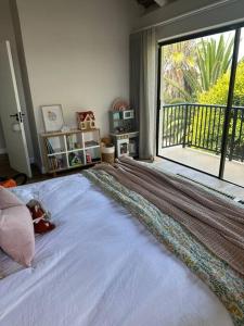 a bedroom with a large bed with a large window at Laid back luxury canal house in St Francis Bay