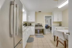 een keuken met witte kasten en een witte koelkast bij New Orleans Area Home Near the Lake and City Park! in Metairie