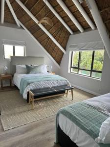 a bedroom with a bed and two windows at Laid back luxury canal house in St Francis Bay