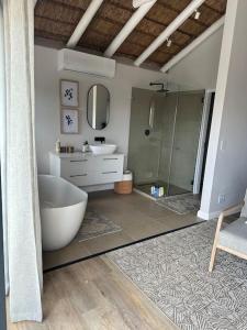 a bathroom with a tub and a sink and a shower at Laid back luxury canal house in St Francis Bay