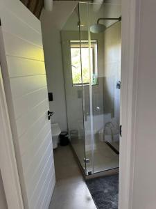 a bathroom with a glass shower with a window at Laid back luxury canal house in St Francis Bay