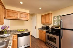 a kitchen with stainless steel appliances and wooden cabinets at The Querque Hotel in Albuquerque
