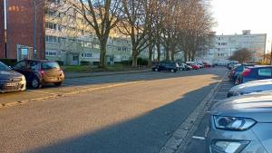 une rue avec des voitures garées sur le côté de la route dans l'établissement Beau T3 à 5 min du Grand Stade avec parking gratuit, à Villeneuve d'Ascq