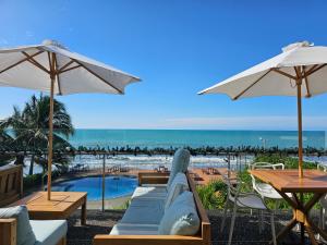 una vista sulla spiaggia da un patio dell'hotel con ombrelloni di Departamentos frente al mar Resort Playa Azul a Tonsupa