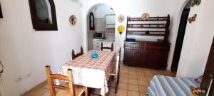 a dining room with a table and a kitchen at Villetta Bedogni in Simius