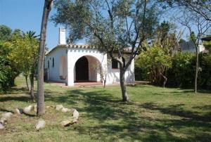 a small white house with an archway in a yard at Villetta Bedogni in Simius