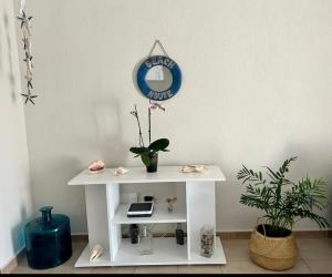 アカンティラド・デ・ロス・ヒガンテスにあるApartamento cerca de la playaの小さな白いテーブル(植物と鏡付)