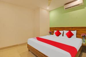 a bedroom with a large bed with red pillows at Flagship Hotel R Square in Warangal