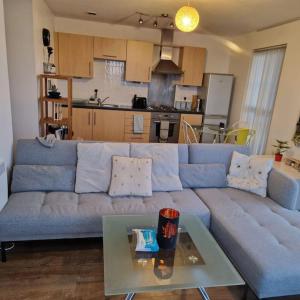 a living room with a blue couch and a table at Two Bed in Sportscity Manchester in Manchester