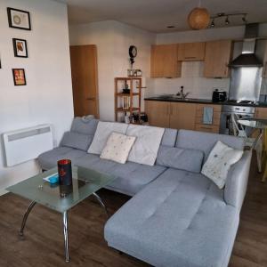 a living room with a blue couch and a table at Two Bed in Sportscity Manchester in Manchester