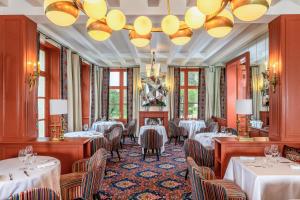 un restaurant avec des tables, des chaises et un lustre dans l'établissement Hotel Les Hautes Roches, à Rochecorbon