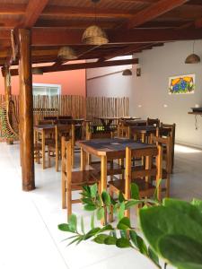 a restaurant with wooden tables and wooden chairs at Pousada Refúgio das Flores in Ubatuba