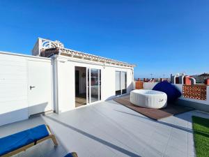 un patio all'ultimo piano con tavolo e sedie sul tetto di St George's Apartments - Gran Canaria a Telde