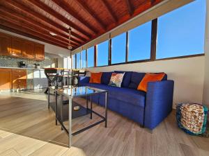 a living room with a blue couch and a table at St George's Apartments - Gran Canaria in Telde