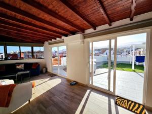 ein Wohnzimmer mit Glasschiebetüren und einem Balkon in der Unterkunft St George's Apartments - Gran Canaria in Telde