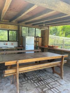 una gran mesa de madera en una cocina con ventanas en Verde viento, en La Paloma