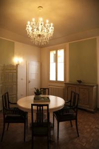 een eetkamer met een tafel en stoelen en een kroonluchter bij Belle Epoque in Faenza
