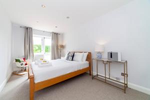 a bedroom with a large bed and a window at Hidden treasure 2 BR ground floor apt, Brentford in Brentford