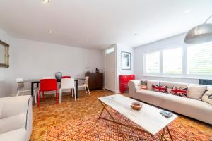 ein Wohnzimmer mit einem Sofa und einem Tisch in der Unterkunft Hidden treasure 2 BR ground floor apt, Brentford in Brentford