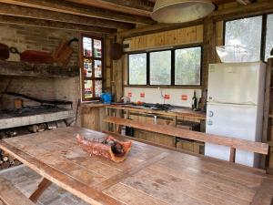 cocina con mesa de madera y nevera en Verde viento, en La Paloma