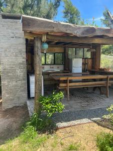 un pabellón con mesa de picnic y cocina en Verde viento, en La Paloma