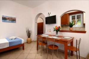 una habitación con una mesa y sillas y una cama en Barbati View Luxury Hotel Apartments, en Barbati