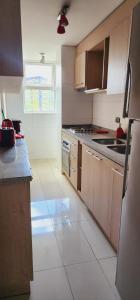 uma cozinha com um frigorífico e um fogão forno superior em Dpto Vita3 2D2B Puerto Varas em Puerto Varas