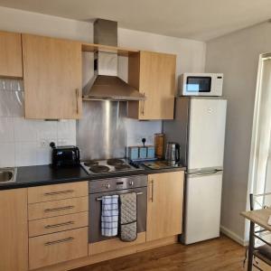 a kitchen with a stove and a refrigerator at Two Bed in Sportscity Manchester in Manchester