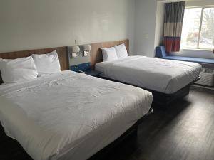 a hotel room with two beds and a window at Microtel Inn by Wyndham Atlanta Airport in Atlanta