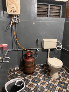 a small bathroom with a toilet and aepergeist at Vintage Walls Homestay in Hampi