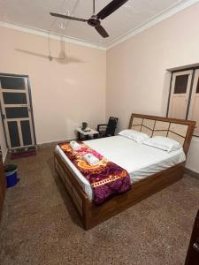 a bedroom with a bed and a ceiling fan at Vintage Walls Homestay in Hampi