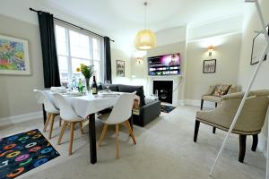 een woonkamer met een tafel en stoelen en een woonkamer bij STUNNING 4 BEDROOM FLAT IN REGENT'S PARK - ABBEY Rd in Londen