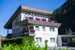 un edificio bianco con fiori sul balcone di Rainer's Appartements a Längenfeld