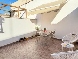 einen kleinen Balkon mit einem Tisch und Stühlen in der Unterkunft Concept Sicily in Syrakus