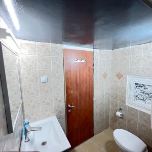 a bathroom with a toilet and a wooden door at Happy Home in Eilat