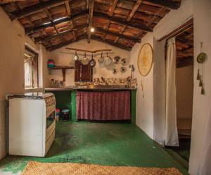 a kitchen with a stove and a green floor at Casinha privativa sem suíte. in Vale do Capao