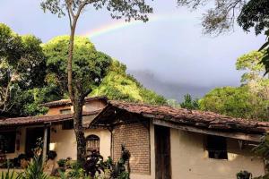 a rainbow in the sky above a house at Casinha privativa sem suíte. in Vale do Capao